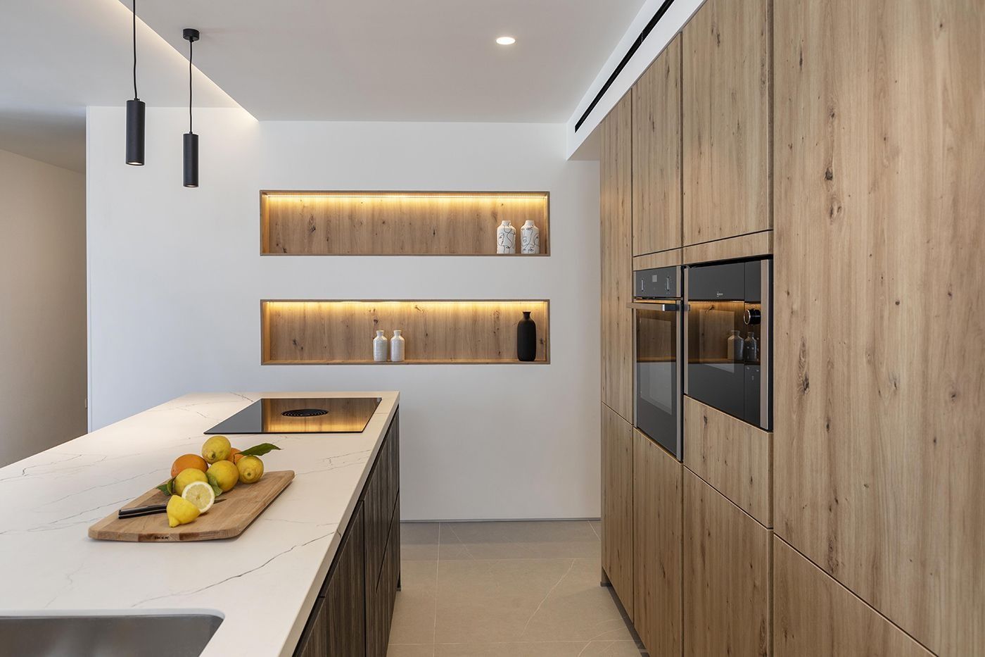 Una cocina con gabinetes de madera y una tabla de cortar con limones encima.