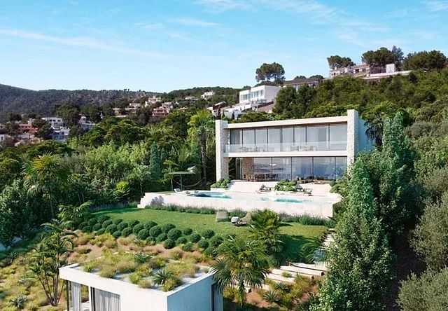 Una gran casa blanca está situada en la cima de una colina rodeada de árboles.