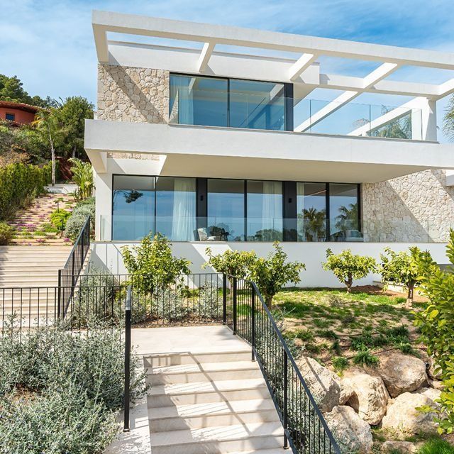 Una gran casa blanca con muchas ventanas y escaleras que conducen a ella.