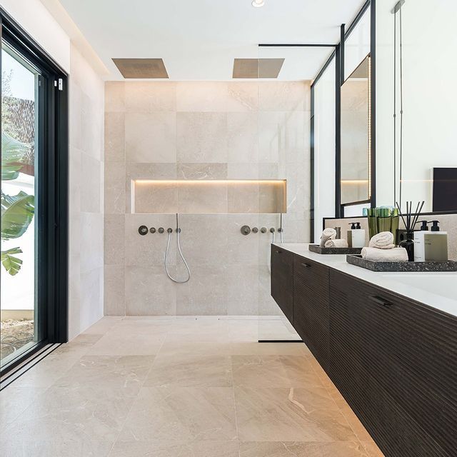 Un baño con ducha a ras de suelo y lavabo.