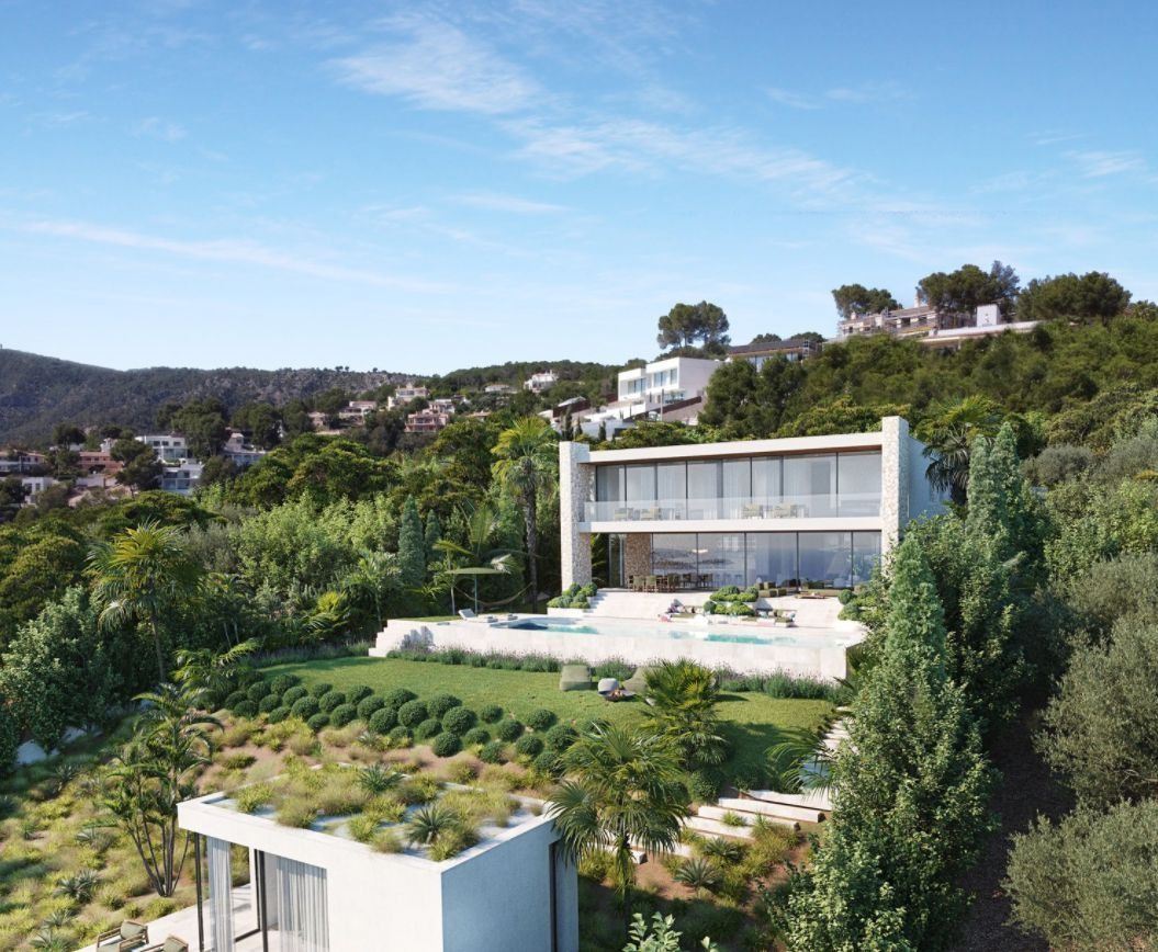 Una vista aérea de una casa moderna en la cima de una colina rodeada de árboles.