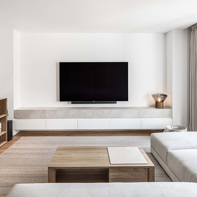 Una sala de estar con un televisor de pantalla plana en la pared.