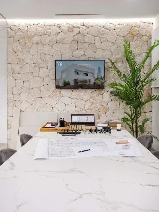 Una sala de conferencias con una mesa y sillas y un televisor en la pared.