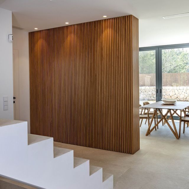 Un comedor con una pared de madera y escaleras.
