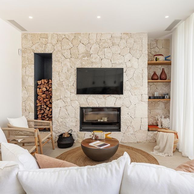 Una sala de estar con chimenea y TV de pantalla plana.
