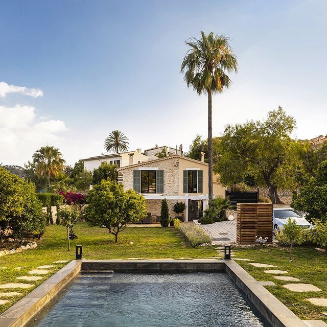 Una casa grande con piscina delante de ella.