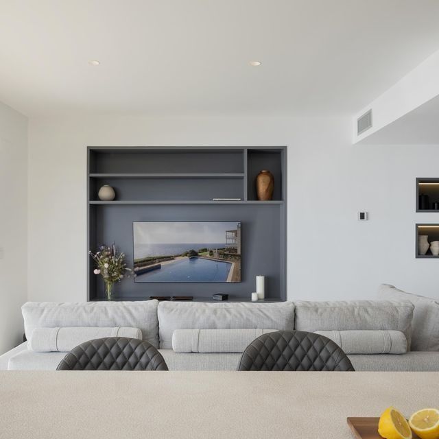 Una sala de estar con un sofá y un televisor en la pared.