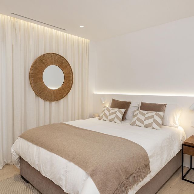 Un dormitorio con una cama y un espejo en la pared.