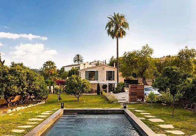 Una casa grande con piscina delante de ella.