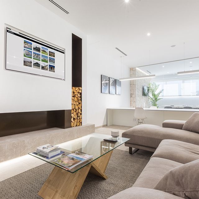 Una sala de estar con un sofá y una mesa de centro de cristal.