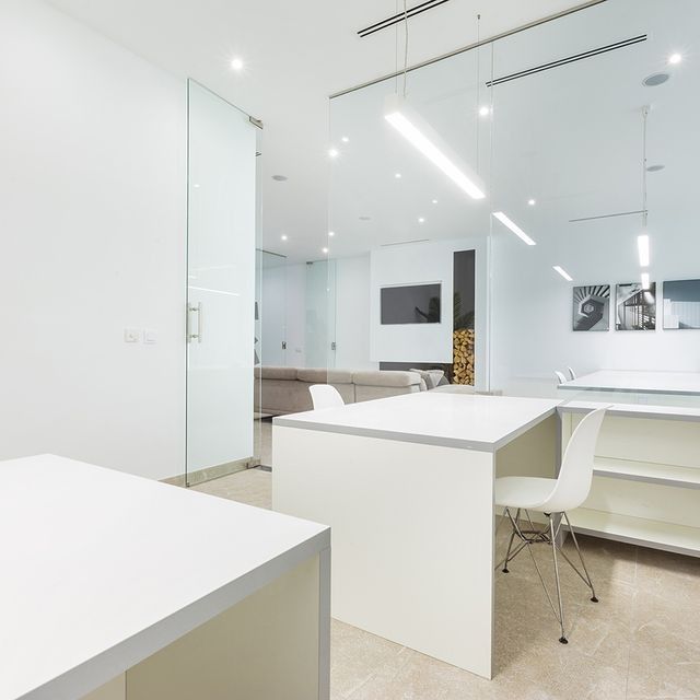 Una sala de estar con una mesa y sillas blancas.