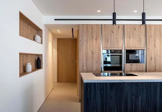 Una cocina con gabinetes de madera y electrodomésticos de acero inoxidable.