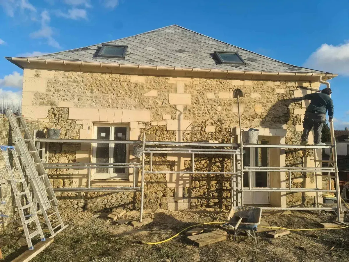 Rénovation de façade de maison avec échafaudages.