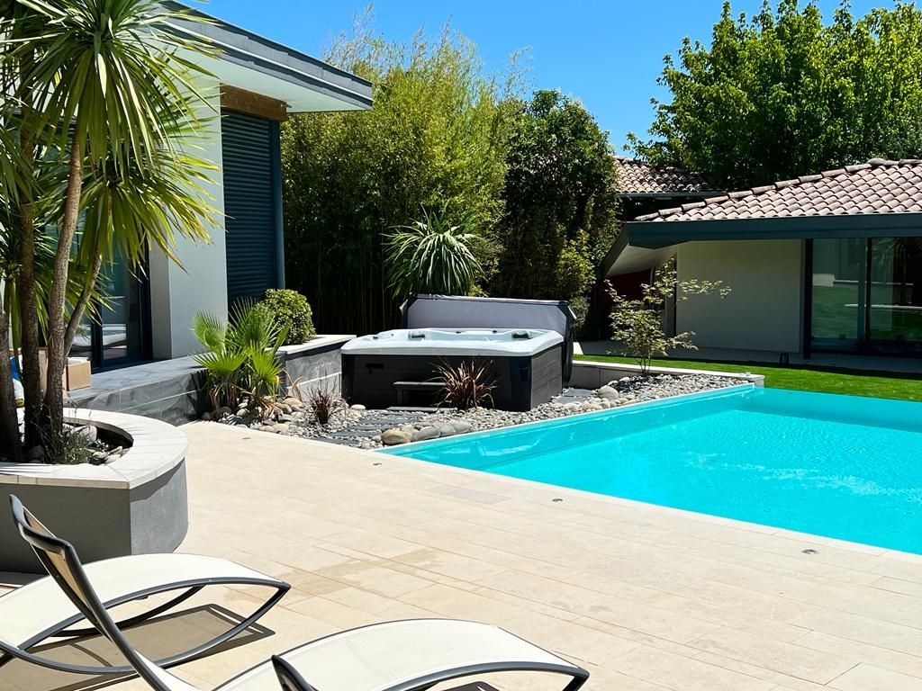 Un spa de la marque Vendom près d'une piscine.