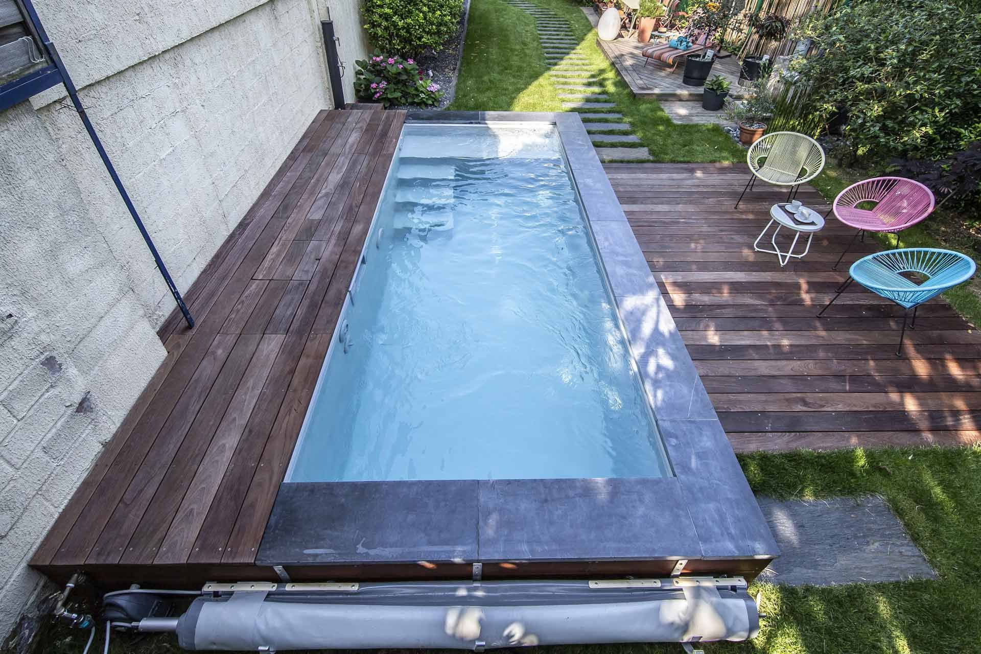 Longue piscine située entre une maison et une terrasse
