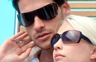 Un hombre y una mujer con gafas de sol están sentados uno al lado del otro.