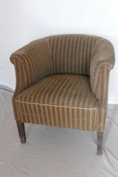 Ein braun gestreifter Stuhl steht auf einer weißen Decke.