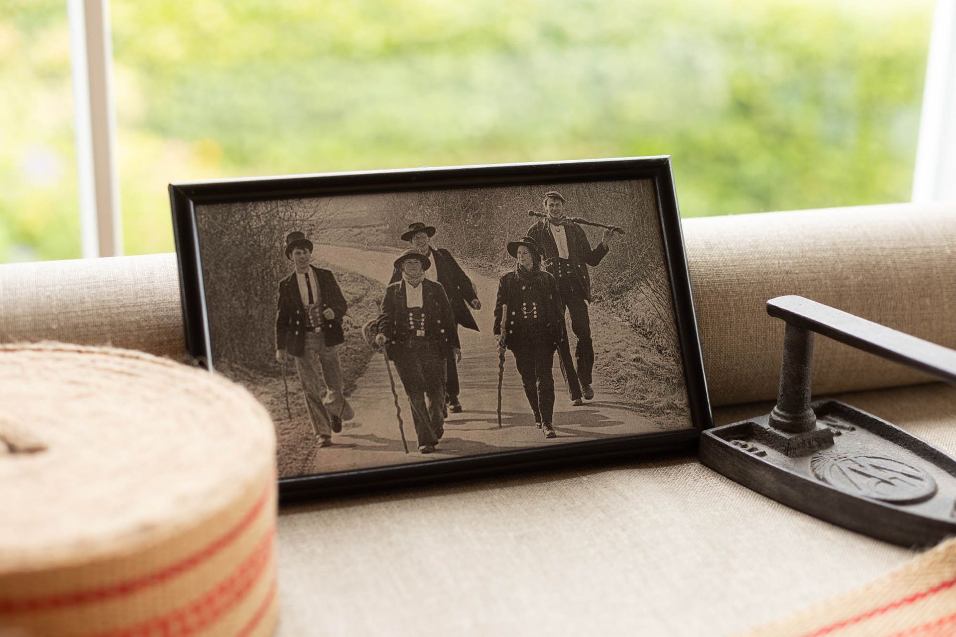 Ein Schwarzweißfoto von drei Männern, die auf einem Sofa laufen