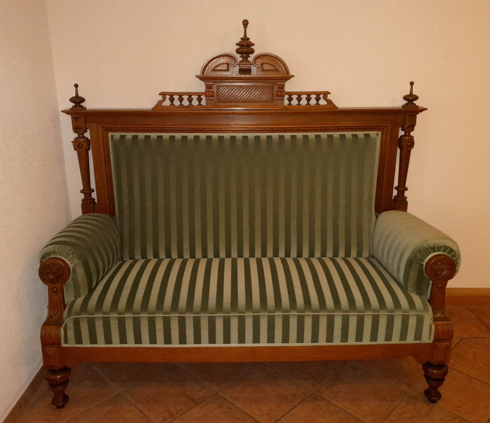 Eine grün-weiß gestreifte Couch mit Holzrahmen