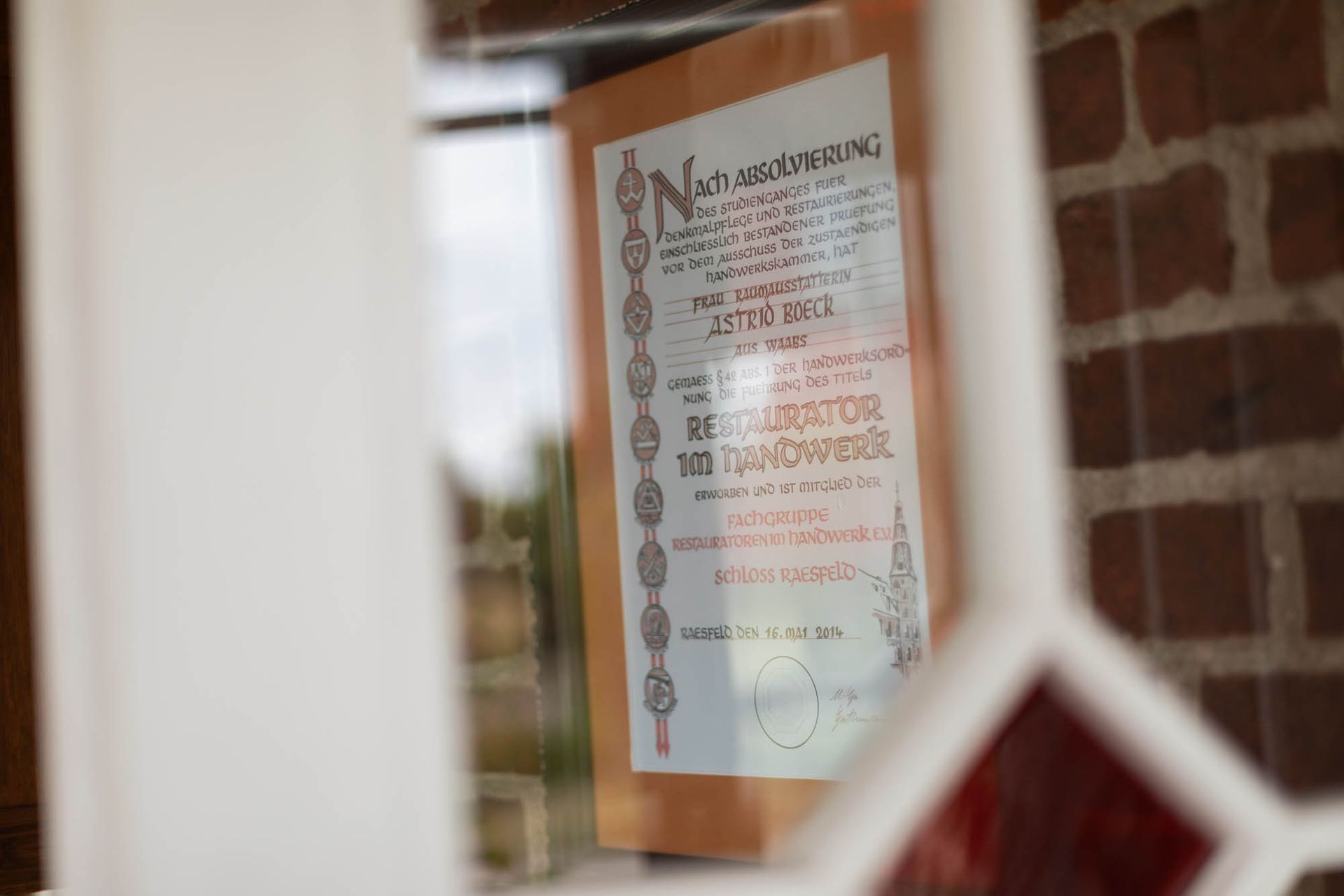 Ein Buntglasfenster mit einem daran hängenden Schild