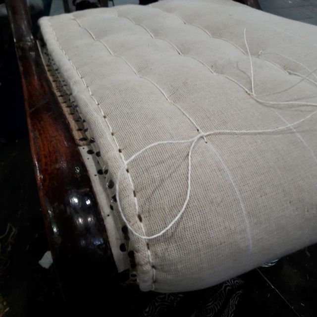 Ein Stuhl mit Kissen wird repariert.