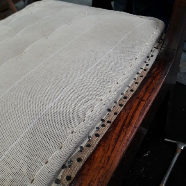 Ein Holzstuhl mit einem weißen Kissen darauf