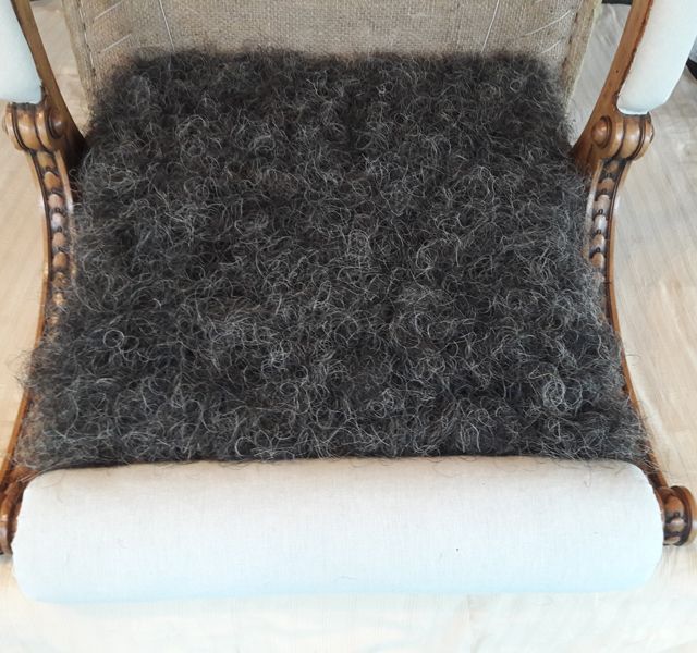 Eine Nahaufnahme eines Stuhls mit einem Teppich darauf.