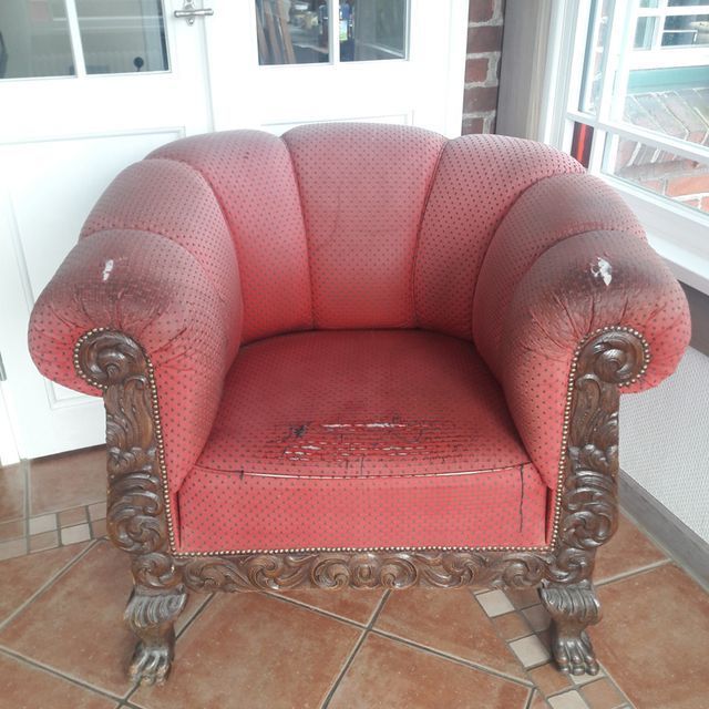 Ein roter Stuhl steht auf einem gefliesten Boden vor einer Tür