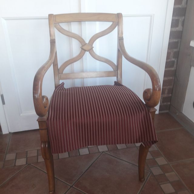 Ein Holzstuhl mit rot gestreiftem Sitzkissen