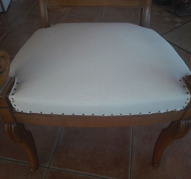 Ein Holzstuhl mit einem weißen Kissen darauf