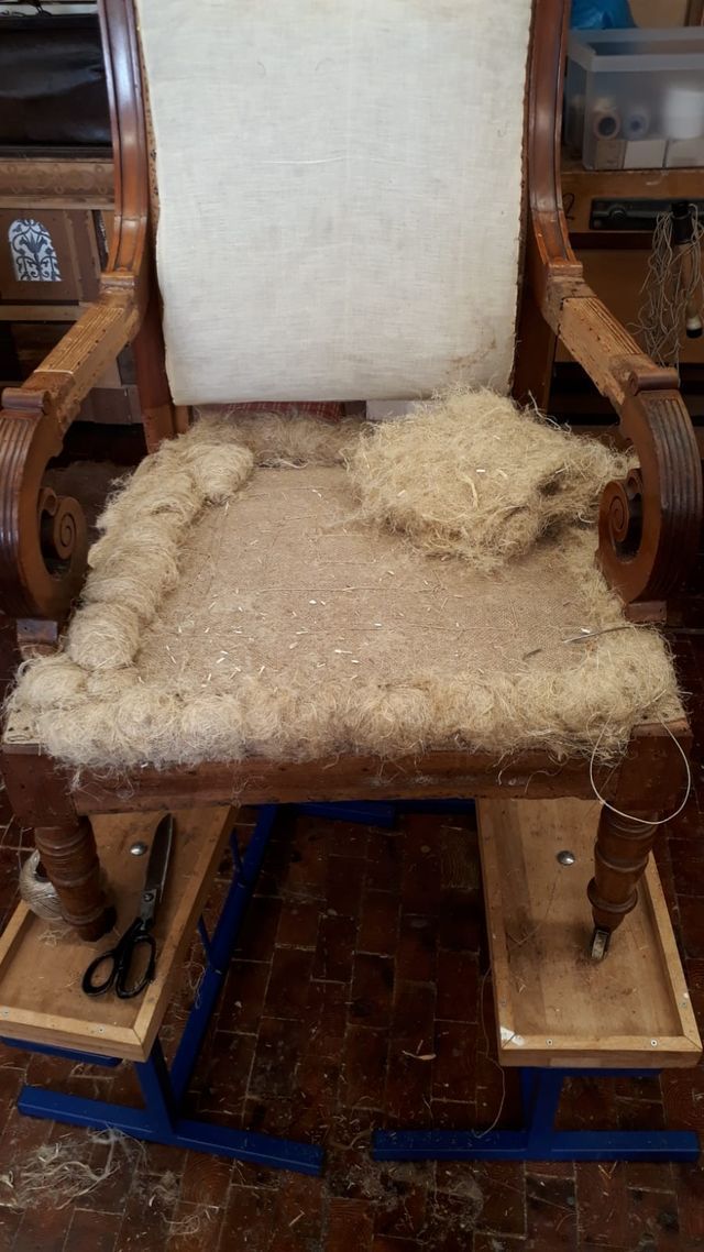 Auf einem Holztisch steht ein Schaukelstuhl mit einem Kissen.