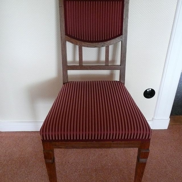 Ein Holzstuhl mit rot-weiß gestreifter Sitzfläche