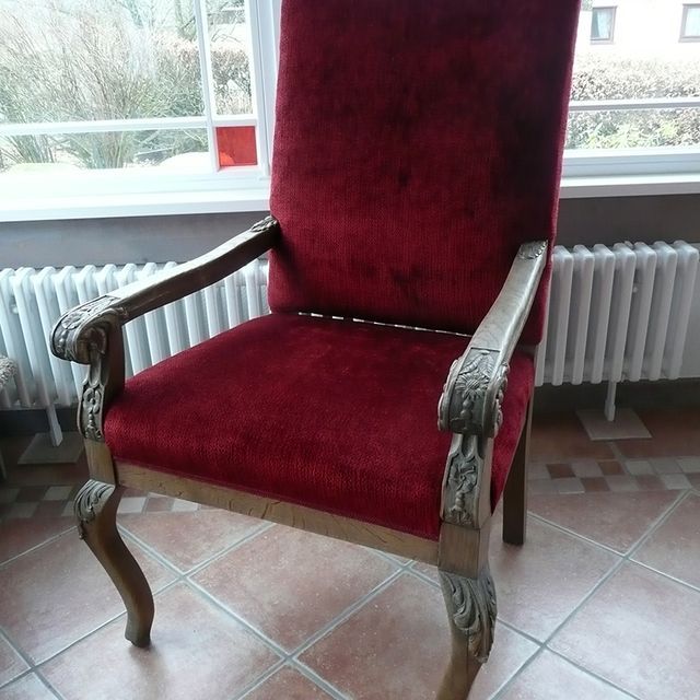 Ein roter Stuhl steht vor einem Fenster