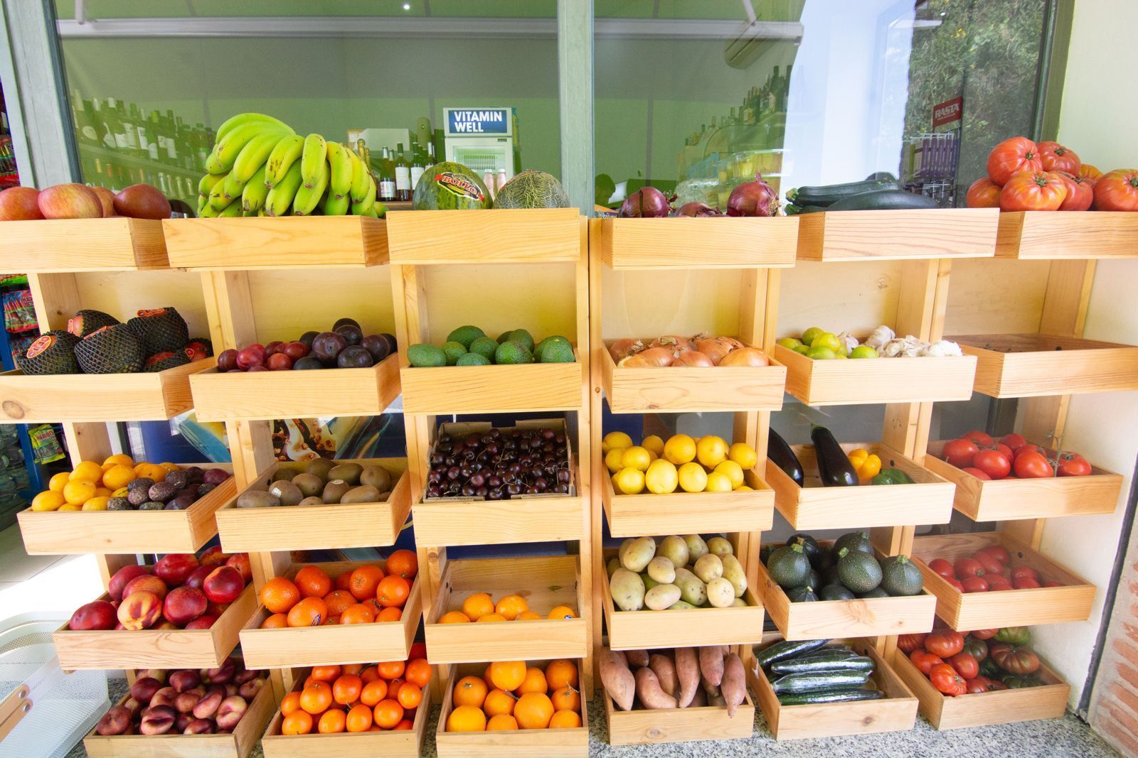 Una variedad de frutas y verduras están dispuestas en un arco iris de colores.