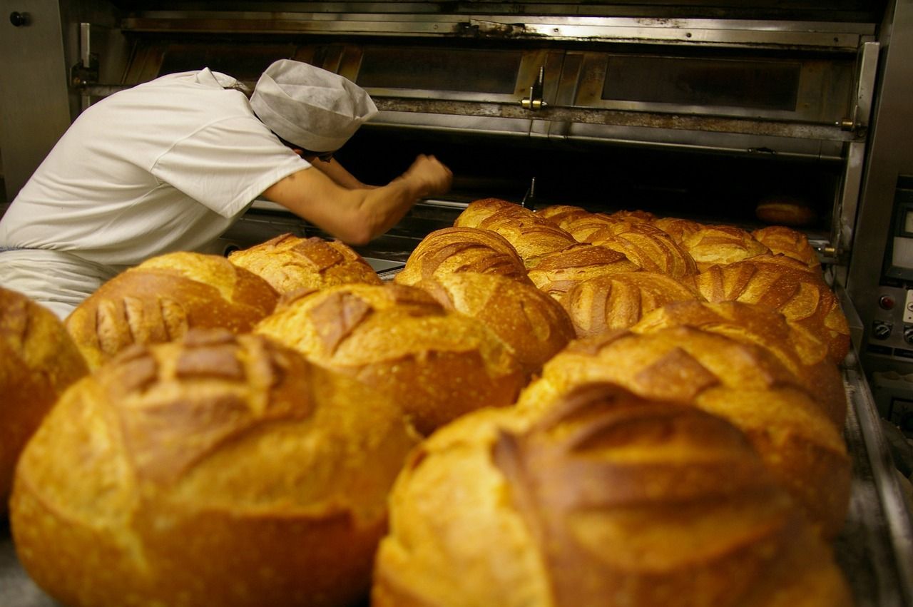 Un panadero está sacando el pan del horno.