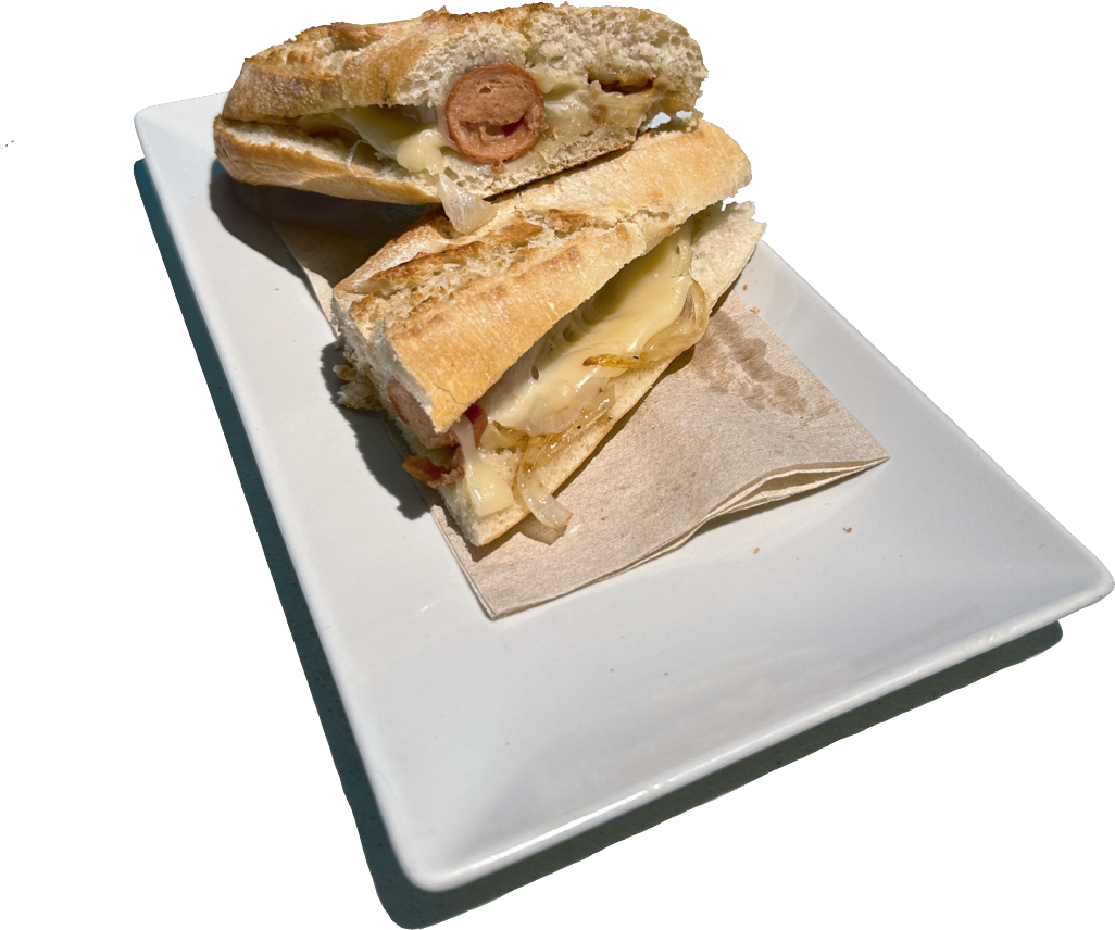 Un sándwich con queso y tomates en un plato blanco.