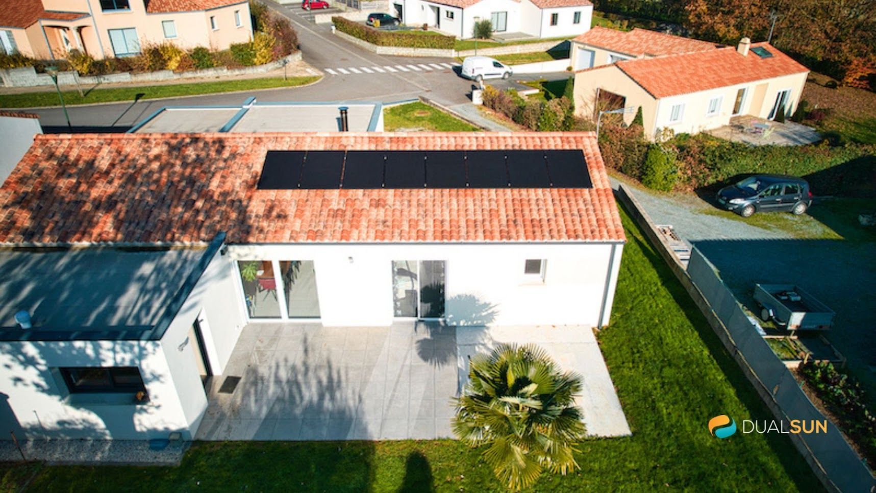 Photo d'une maison blanche, vue aérienne avec des panneaux photovoltaïques sur le toit