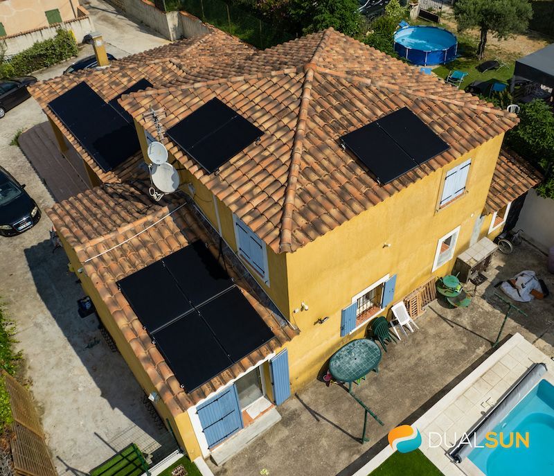 Photo d'une maison jaune, vue aérienne avec des panneaux photovoltaïques sur le toit