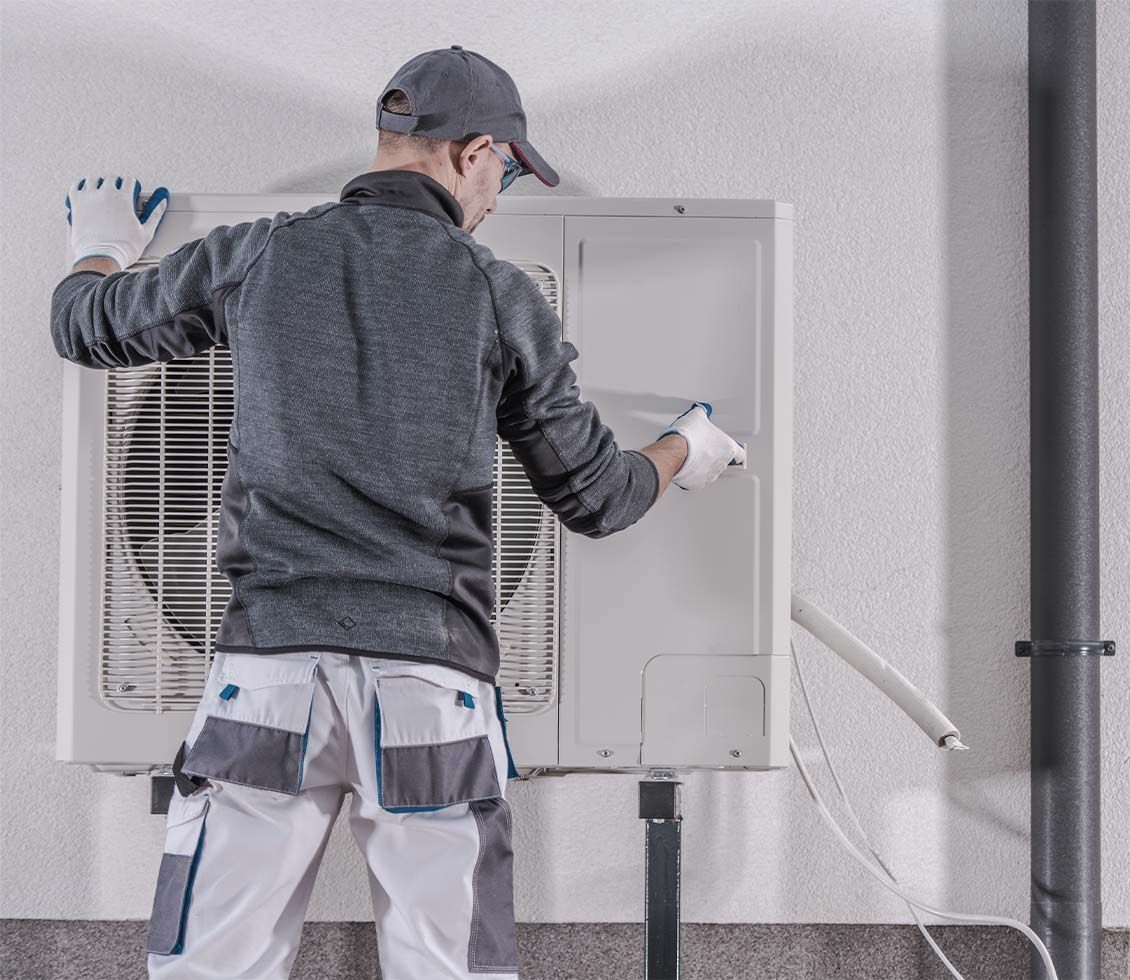Un chauffagiste installe une pompe à chaleur