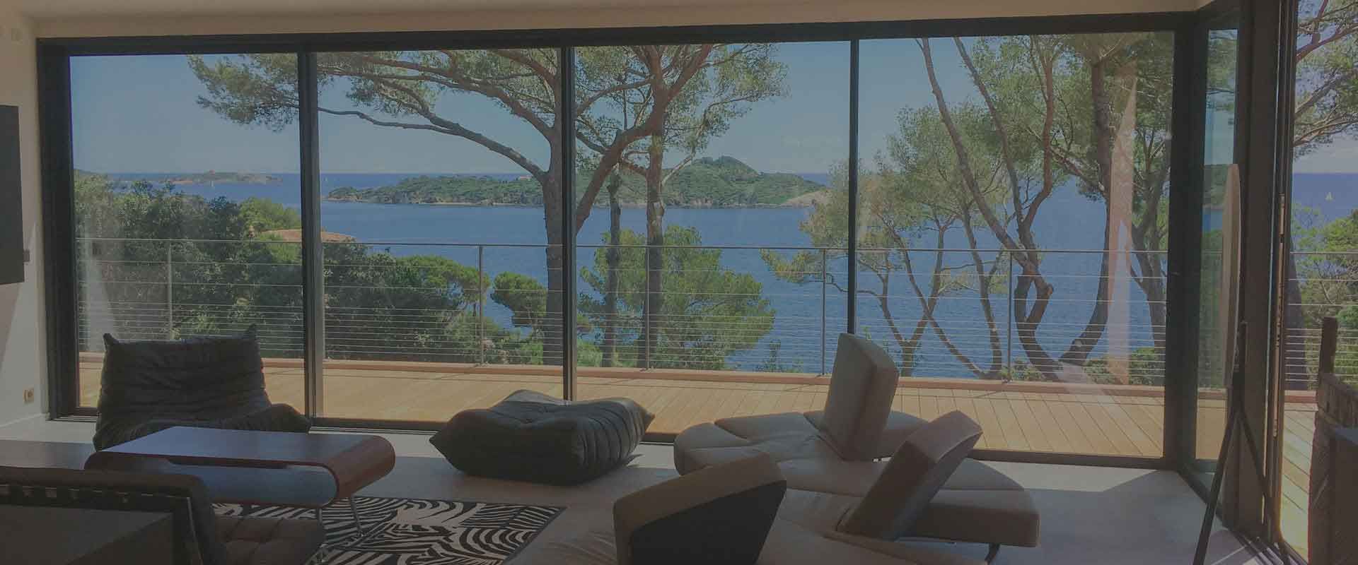 Photo d'un salon avec grande baie vitrée, vue sur la mer