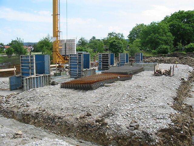 Eine Baustelle mit einem Kran im Hintergrund und einem Haufen Steine