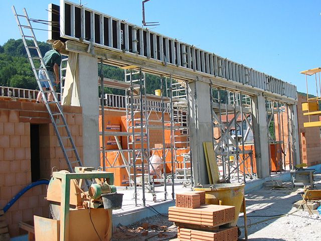 Ein Mann steht auf einer Leiter an einer Baustelle