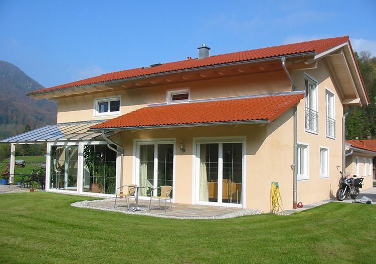 Schlüsselfertiger Neubau mit rotem Dach und Terrasse