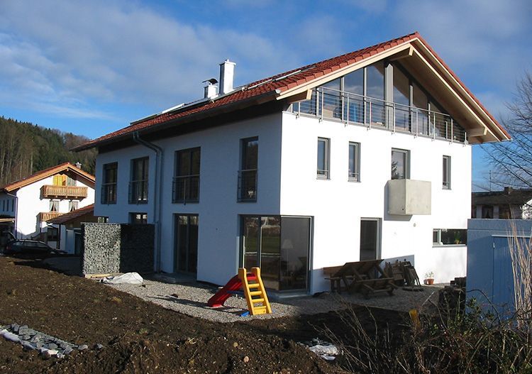 Schlüsselfertiger Neubau mit rotem Dach und Fenstern