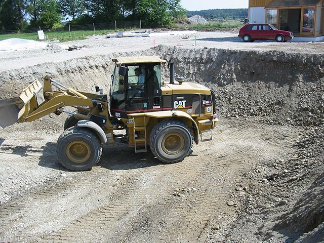 ein Cat-Traktor fährt durch einen Graben
