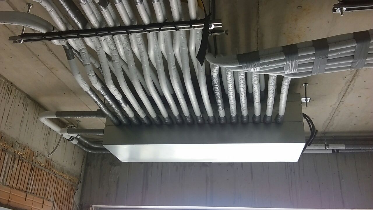 Elektrische Leitungen in einer Betondecke, sauber gebündelt und gesichert, mit einem Verteilerkasten aus Metall.