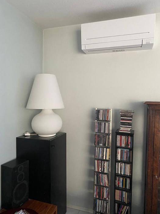 Klimaanlage über dem CD-Regal, Lampe auf Lautsprecherständer in der Zimmerecke.