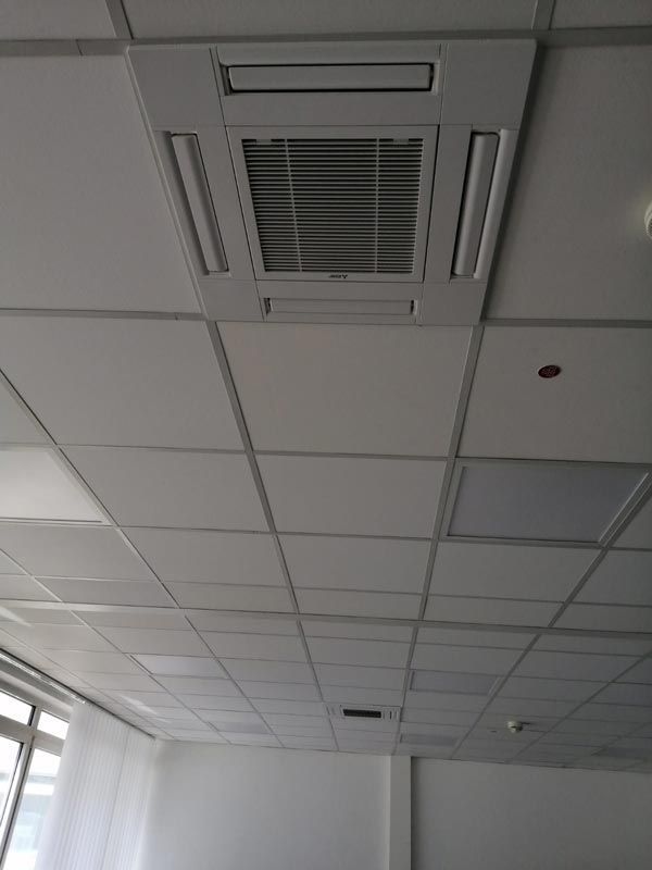 Weiße Bürodecke mit zentraler Klimaanlage.