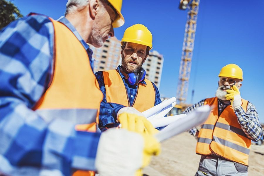 Un grupo de trabajadores de la construcción se encuentra en un sitio de construcción.