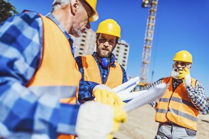 Un grupo de trabajadores de la construcción se encuentra en un sitio de construcción.